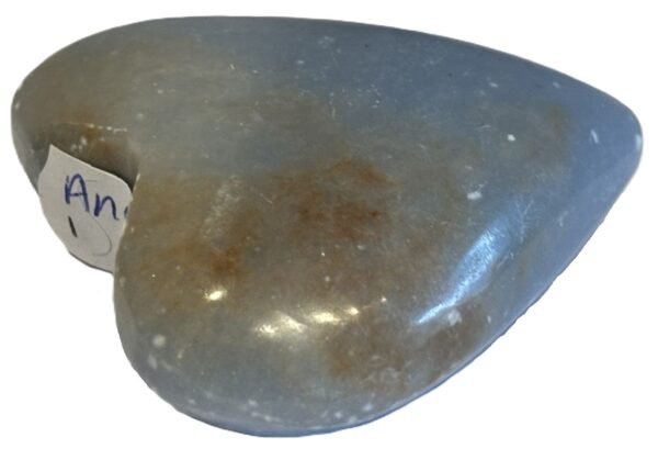 Polished natural angelite carved heart crystal 1 sians emporium Smooth polished blue angelite carved heart crystal showing natural white mineral flecks on a white background